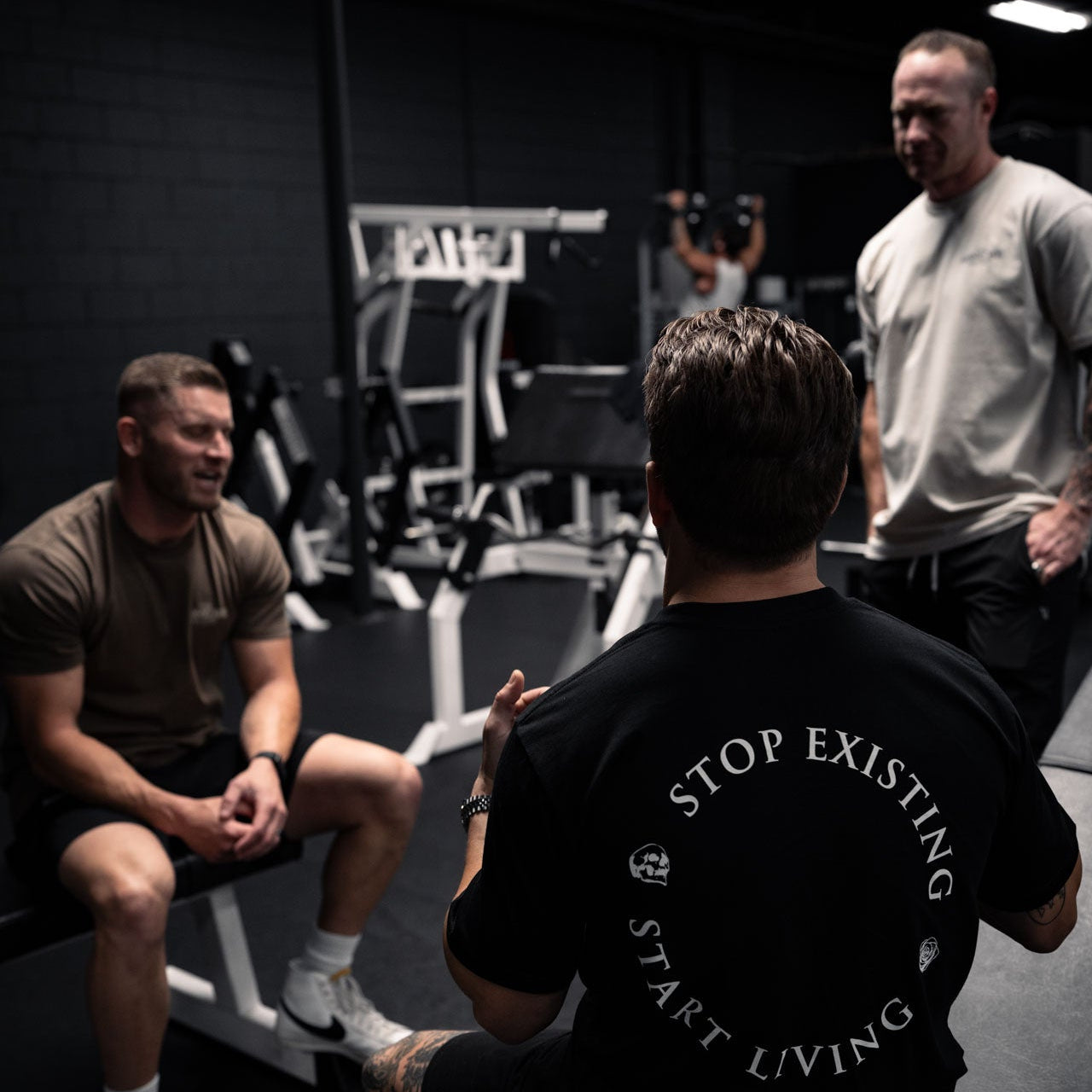 Person wearing a black t-shirt with motivational quote in a gym setting